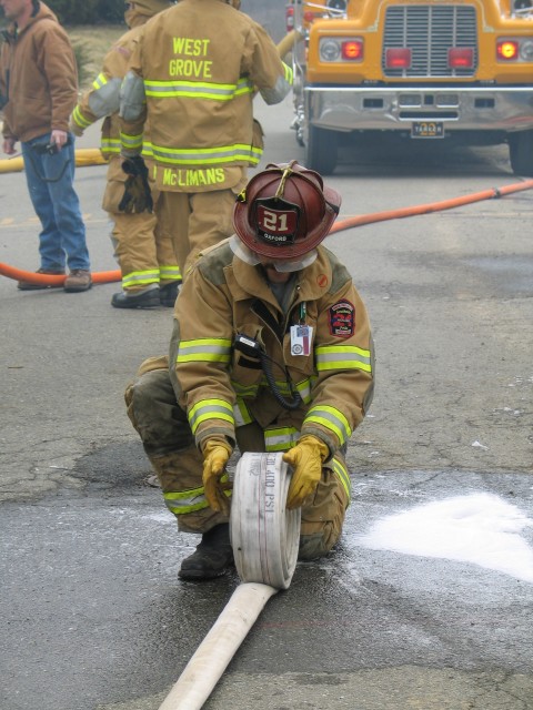 Firefighter Mike Nelson rolling hose.